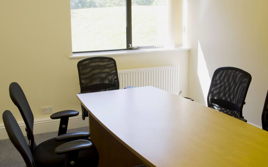 The small meeting room, with a table and mesh chairs